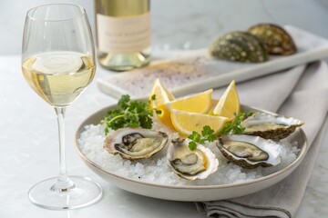 food and wine pairing Elegant oysters served on ice with lemon and a glass of white wine.