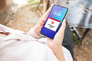 Emergency alert warning displayed on smartphone screen as symbols telling people to be careful....