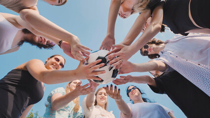 High school students coming together in unity and teamwork, forming a circle and holding a soccer ball during summer break
