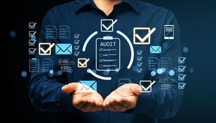 Businessman holding digital audit icons with checklist and email symbols on dark background representing modern technology and compliance concept.