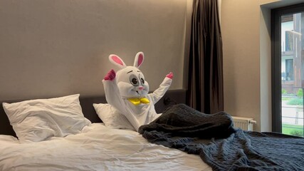 An Easter Bunny mascot wakes up in bed, stretching to start the day. A fun and whimsical take on a daily routine, perfect for creative Easter content and playful seasonal storytelling