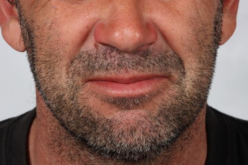Obraz premium Close-up portrait focused on the lower face of a 45-year-old man, showing slight facial hair and mature skin texture