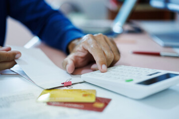 asian man calculate monthly expenses from receipt and many bill of various expenses after spending via credit card and must be pay back soon