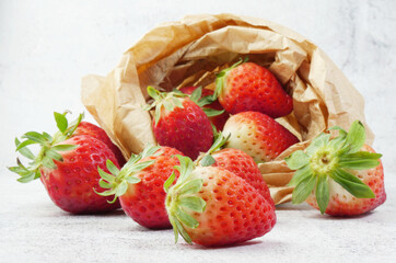 Close up. Set of red strawberries scattered and in kraft paper bag.