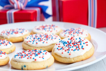 plate of decorated sugar cookies on a white plate with red white and blue sprinkles