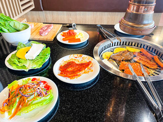 Close up of Korean grilled meat barbecue. Traditional Korean grilled meat as pork was roasted or fired on stainless stove at Korean bbq restaurant. Asian and Korea traditional food concept.
