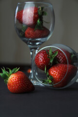 Juicy red berry in the foreground. Strawberries are in the glasses. Farm concept, healthy eating.