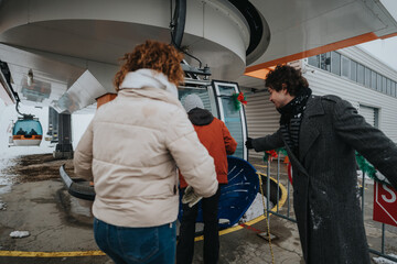 A group of cheerful friends prepares to ride a gondola lift amidst snowy surroundings, showcasing...