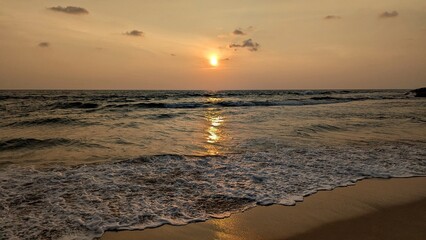 Scenic coastal view of golden sunset over ocean waves at Hikkaduwa on South Coast of Sri Lanka