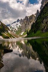 Fälensee on a spring tour in the Alpstein photographed with beautiful reflections of the mountain peaks. It is a lake in the Alpstein range of the canton of Appenzell Innerrhoden, Switzerland at 1446m
