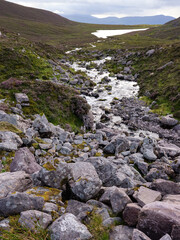 Obraz premium Scenic view of the Cottoners River winding through the rugged landscape of Ireland’s countryside.