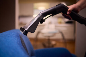Using a Vacuum Cleaner for Upholstery Cleaning in a Modern Interior Design Setting