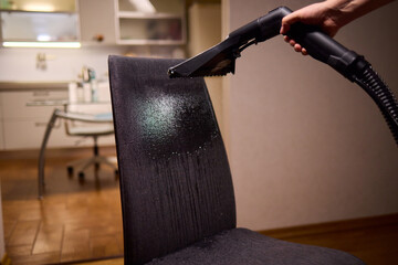 Using a Vacuum Cleaner for Upholstery Cleaning in a Modern Interior Design Setting