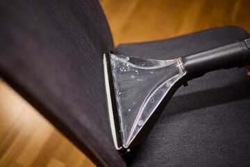 Using a Vacuum Cleaner for Upholstery Cleaning in a Modern Interior Design Setting