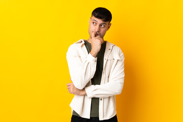 Young Colombian man isolated on yellow background nervous and scared