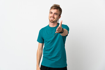 Young handsome man isolated on white background shaking hands for closing a good deal