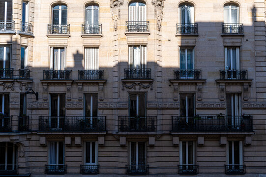 Fa&ccedil;ade ensoleill&eacute;e d'immeuble ancien &agrave; Paris avec l'ombre de l'immeuble en face