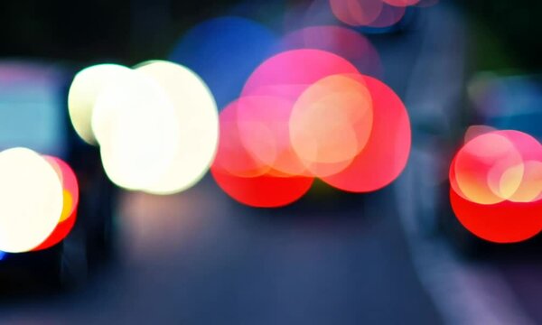 Blurred bokeh of cars in traffic on the road at night. Abstract bright blurred colored bokeh.