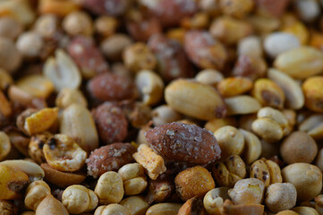 Vibrant mixture of seeds and grains captures the essence of a bountiful harvest in an outdoor market setting during a sunny afternoon