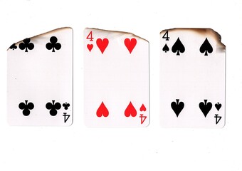 A hand of three burnt playing cards of the same value.