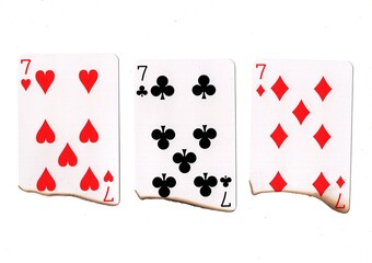 A hand of three burnt playing cards of the same value.