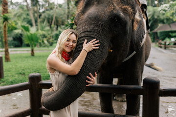 Fototapeta premium beautiful girl with smiling elephant, elephant village, bali