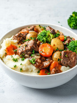 Hearty beef stew with vegetables over egg noodles garnished with fresh parsley