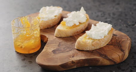 riccotta over orange marmalade on ciabatta slices on wood board
