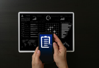 Expenses checklist for payment on the screen of mobile phone. man hands holding phone showing list of what have been paid.