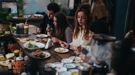 Group of friends dining at a wooden table in a cozy and inviting cafe setting.