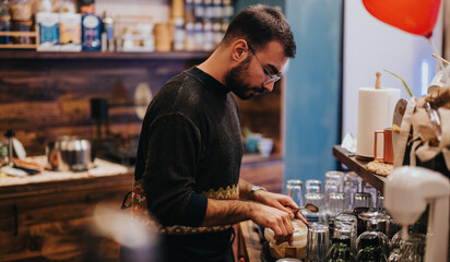 A barista wearing a sweater prepares coffee in a cozy cafe setting, focusing on quality.