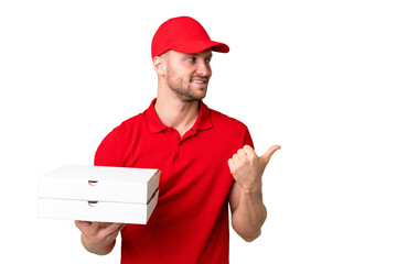 Pizza delivery man with work uniform picking up pizza boxes over isolated chroma key background...