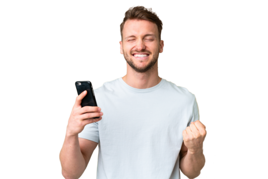 Young handsome caucasian man over isolated chroma key background using mobile phone and doing victory gesture - Powered by Adobe