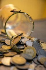 A shattered glass jar with scattered Indian currency coins symbolizes financial instability, economic hardship, or mismanaged savings, representing money loss, poverty, or financial struggles.