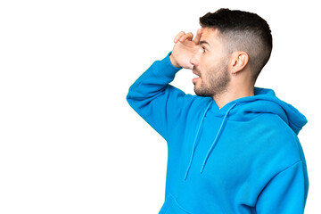 Young handsome caucasian man over isolated chroma key background with surprise expression while looking side