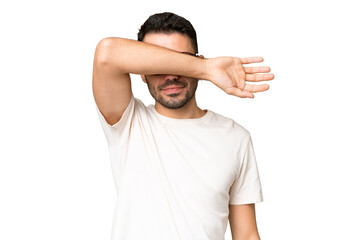 Young handsome caucasian man over isolated chroma key background covering eyes by hands