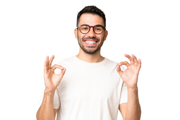 Young handsome caucasian man over isolated chroma key background showing ok sign with two hands