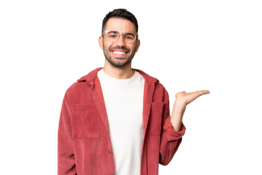 Young handsome caucasian man over isolated chroma key background holding copyspace imaginary on the palm to insert an ad