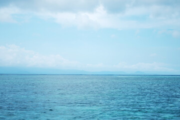 Landscape of horizontal calm blue sea with wave and cloud and blue sky in bright day. Travel destination summer of ocean in Asian. Copy space
