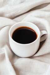 Cup of black coffee on a soft, elegant fabric background, perfect for morning energy.