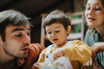 A nurturing scene of a father and mother spending quality time with their child in a warm and...