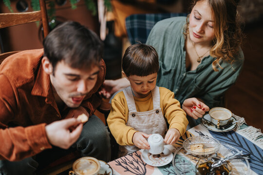 A warm and cozy moment shared by a family enjoying tea and treats together, featuring a loving atmosphere and bonding time.