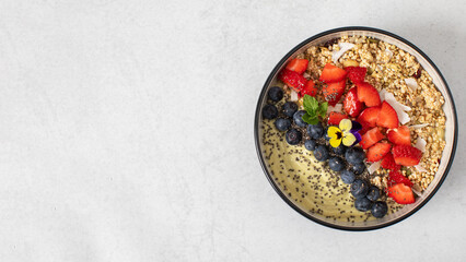  Green smoothie bowl with avocado, granola and berries. Vegetarian, healthy breakfast. Copy space