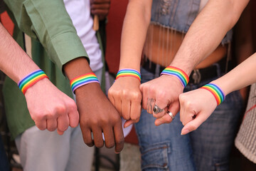 Hands wearing rainbow bracelets, symbolizing support for LGBT rights and equality