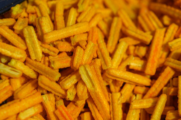 Crunchy yellow snacks displayed at a local market during a vibrant afternoon gathering with friends and family