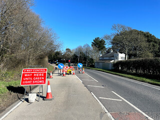 Temporary traffic lights with a when red light shows wait here sign on a residential street.