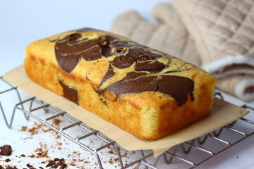 Freshly baked marble cake cooling on a wire rack, showcasing intricate chocolate and vanilla swirls.