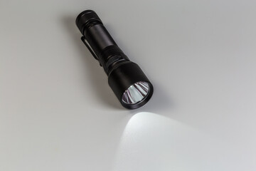 Turned on pocket tactical electric LED mini flashlight