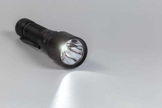Turned on pocket tactical electric LED mini flashlight
