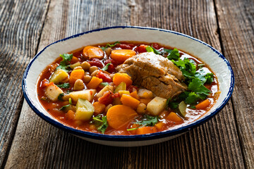 Fresh vegetable soup with chickpeas and meat on wooden table	